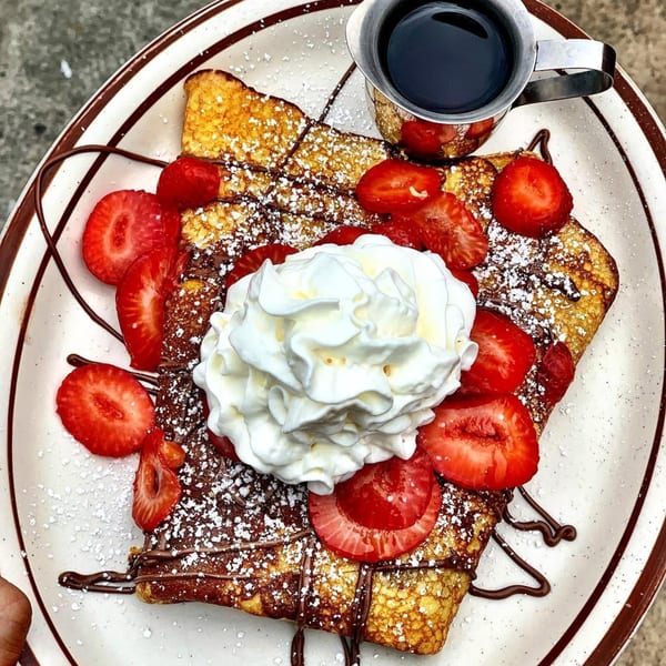 Eat'n Park's French toast with strawberries, whipped cream, chocolate drizzle, and powdered sugar.