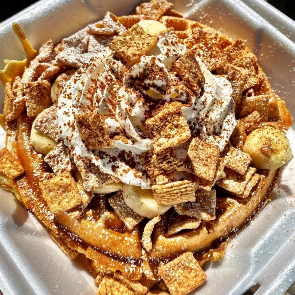 Eat'n Park's waffle topped with whipped cream, cinnamon cereal, banana slices, and powdered sugar.